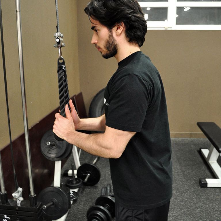 Posición inicial en el ejercicio de extensión de brazos altos con cuerda